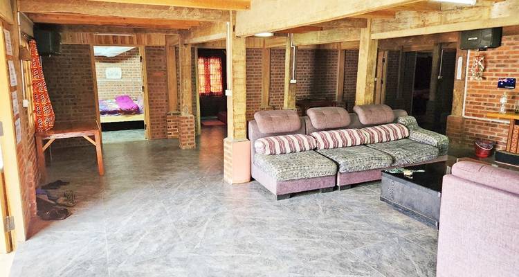 Interior of a traditional house with couches and exposed brick walls.