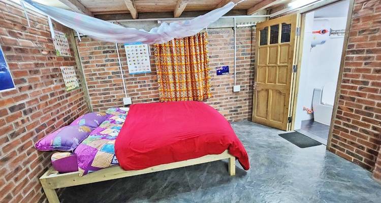 Bedroom with colorful bedding and a netted ceiling.