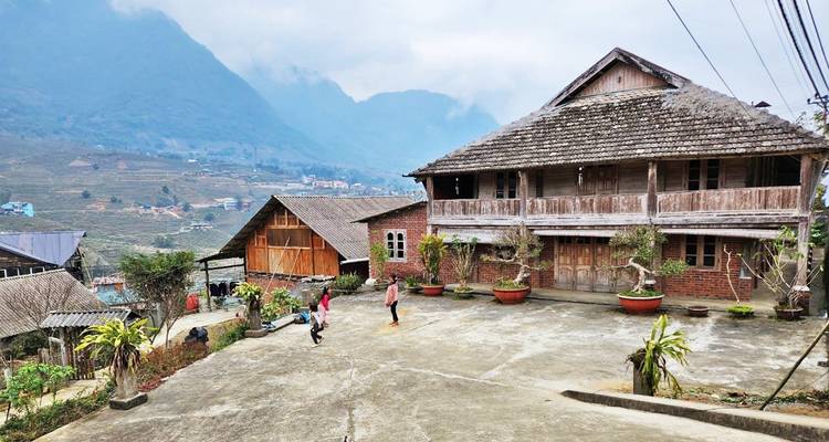 Courtyard of a traditional wooden house with mountain views.