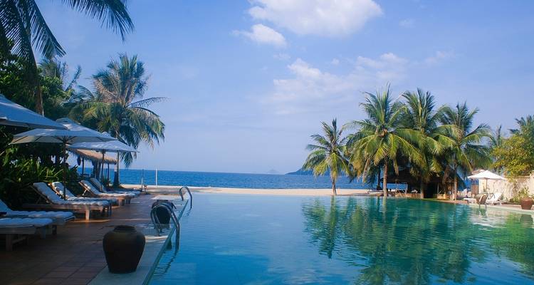 Infinity-Pool mit Blick auf das Meer und Palmen