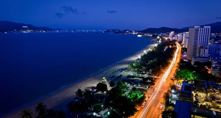 Stadtskyline entlang eines Strandes bei Nacht