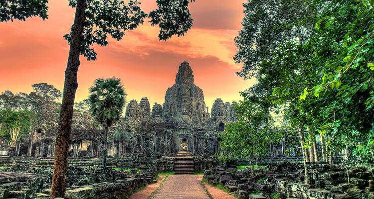 Prachtig uitzicht op een tempel te midden van weelderig groen en een oranje lucht.