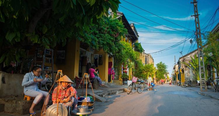 Escena callejera en Hoi An con cafés internet y lugareños.