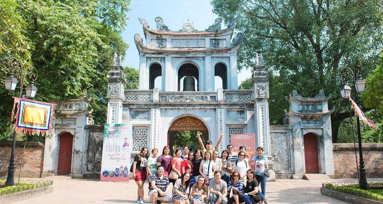 Un grupo de personas posando frente a una puerta histórica.