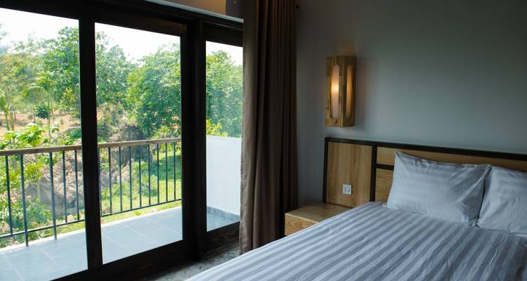 Habitación de hotel con vista a un entorno verde a través de una ventana.
