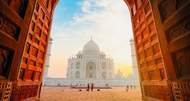 Taj Mahal as seen through an archway with people visiting