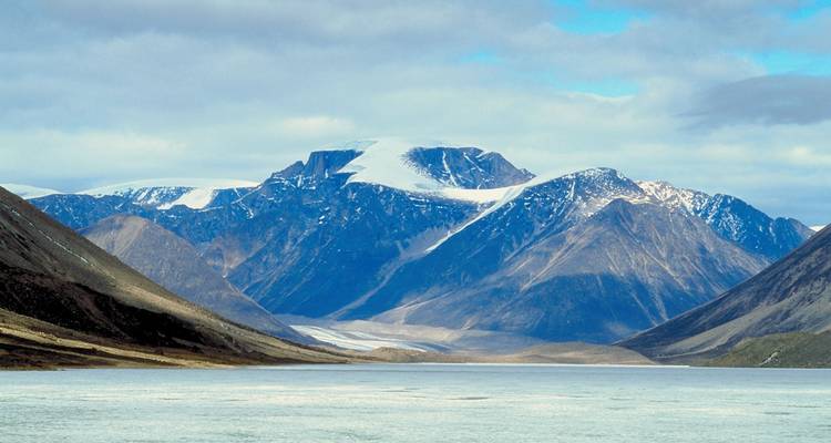 Montagnes enneigées avec une rivière au premier plan.