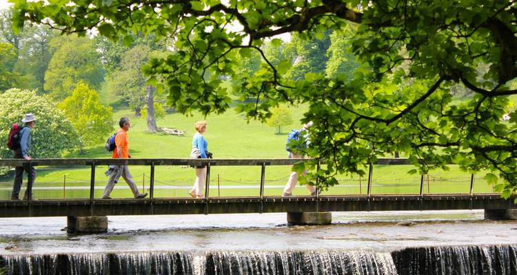 Des gens marchant sur un pont au-dessus d'une petite cascade