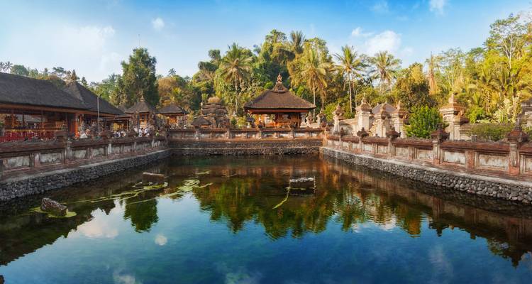 Rustige heilige bronbron omgeven door Balinese tempelwanden en tropische begroeiing