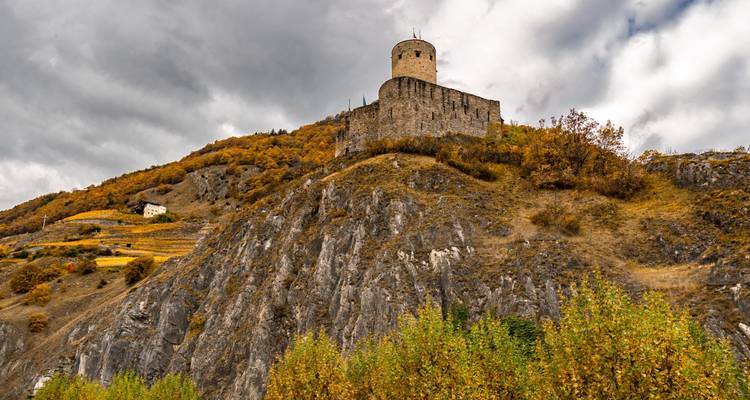 Tour médiévale sur une colline entourée de feuillage d'automne.