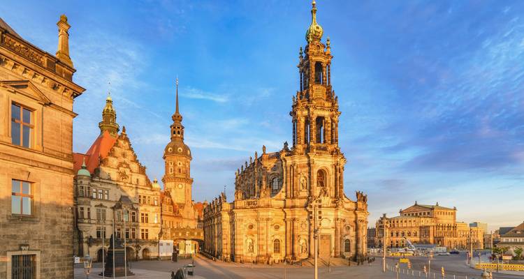 Una iglesia histórica y edificios en una plaza de la ciudad al atardecer.