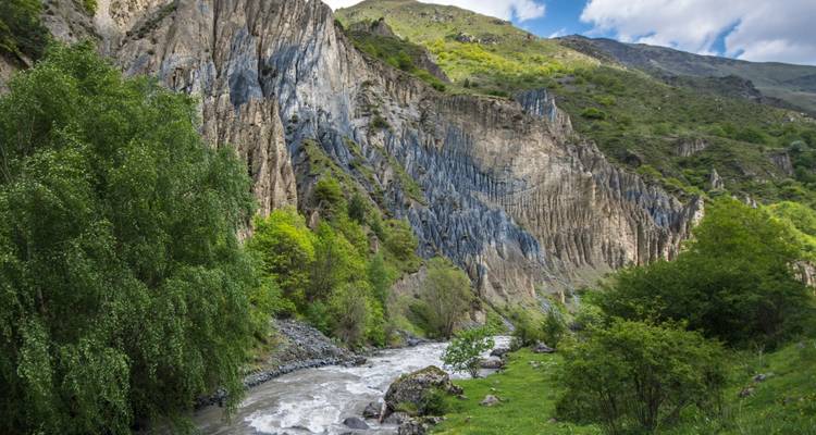 Scenic view of a mountain river winding through lush greenery.