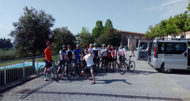 Foto grupal de ciclistas posando con una furgoneta.