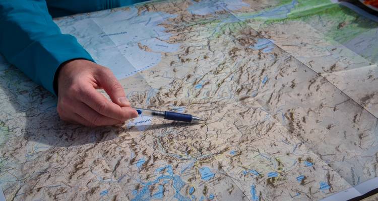 Hand pointing on a detailed map.