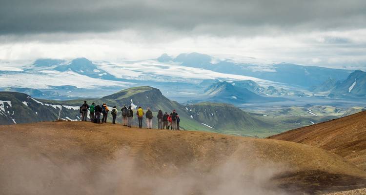 Hikers on a trail with expansive views of the mountains.