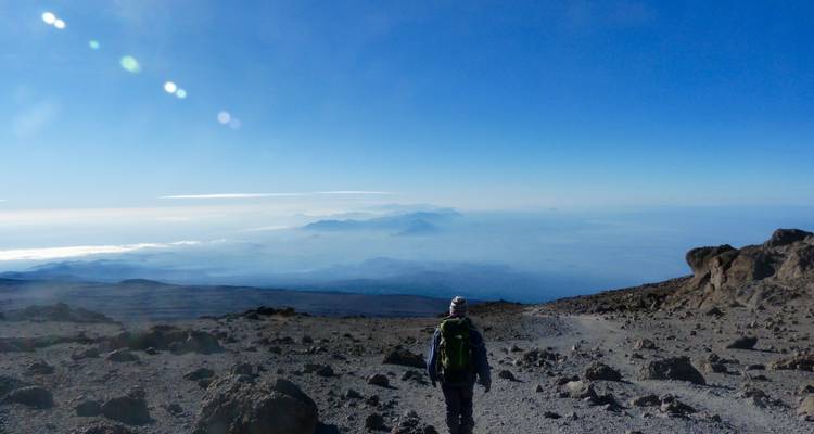 Wandelaar op een rotsachtig pad met weidse uitzichten.