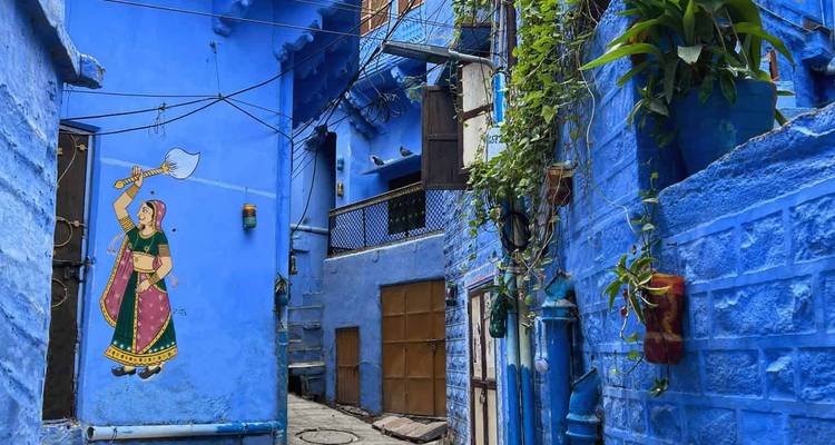 Vibrant blue alley in Jodhpur with wall art of a Rajasthani woman holding a sword