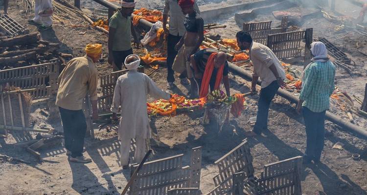 Crematieplechtigheid aan de rivieroever met verzamelde mensen.