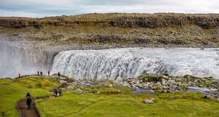 Großer Wasserfall mit Menschen, die auf dem Weg in der Nähe spazieren gehen