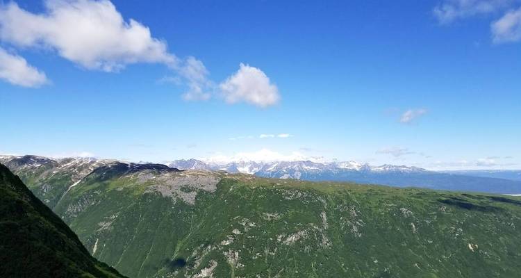 Panoramic view of vast mountain ranges under a clear blue sky.