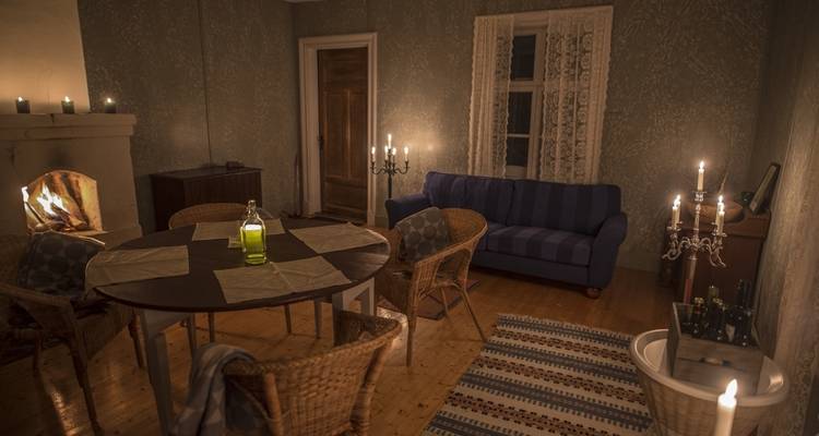 Gezellig interieur met een open haard, eettafel en kaarsen.
