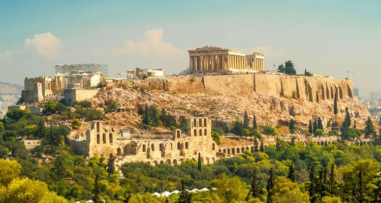 L'Acropole classique d'Athènes, couronnée par le Parthénon, s'élève au-dessus de la ville et de la verdure environnante.