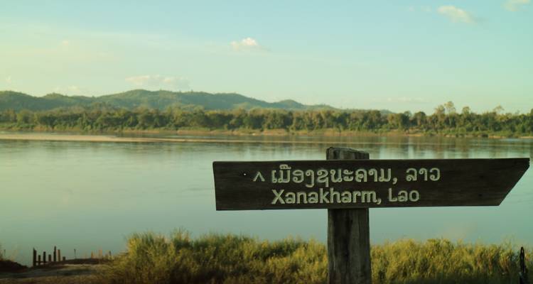 Schild, das auf Xanakham, Lao in der Nähe eines Flusses hinweist.