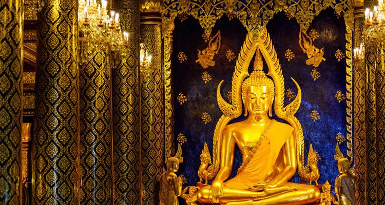 Élégante statue de Bouddha en or à l'intérieur d'un temple orné de lustres.