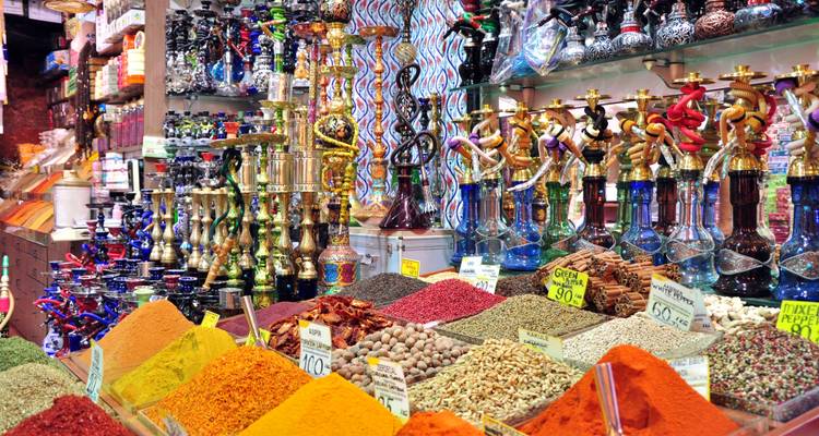 Colorful spice market with vibrant spices and hookahs displayed.