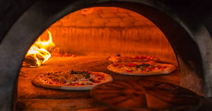 Fresh margherita pizzas being cooked in a stove oven in Naples, Italy