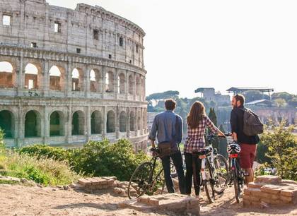 Eine Gruppe Freunde erkundet Rom gemeinsam auf einer Fahrradtour in der Stadt