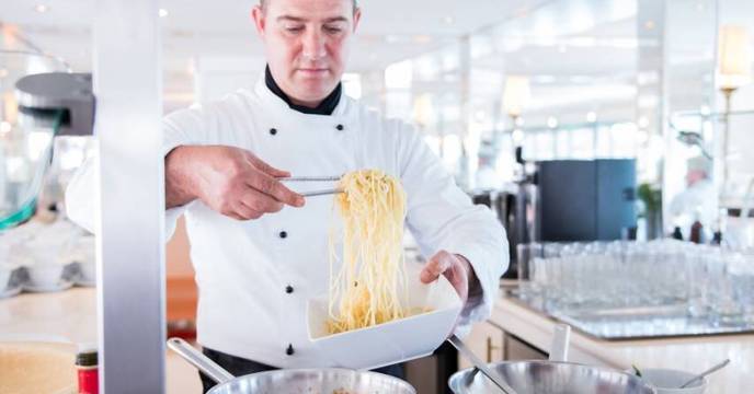 A chef cooking up a 5-star michelin meal onboard a luxury cruise ship