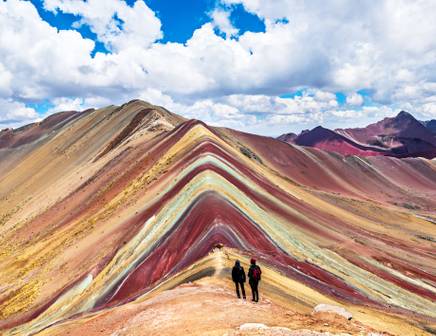 A group of people hiking up the colourful Rainbow Mountain in Peru