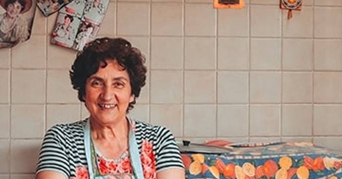 an elderly Italian woman welcoming you into her home