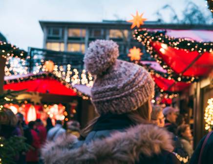 Une femme découvrant la magie des marchés de Noël en Europe