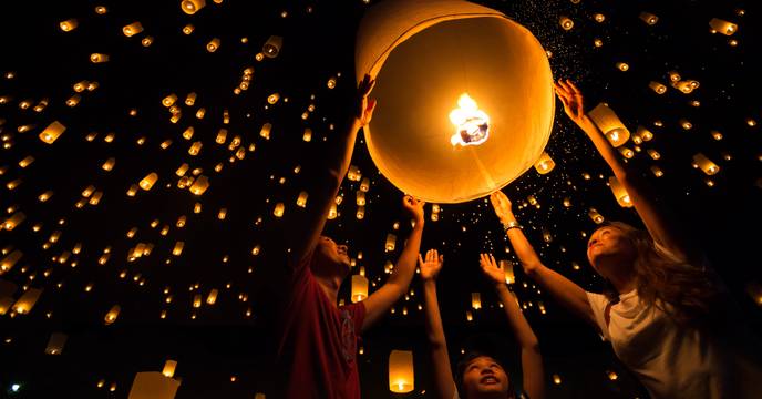 A family on vacation releasing a lantern together at the Lantern Festival in China