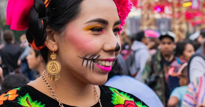 A woman dressed in traditional dress and makeup celebrating the Day of the Dead festival in Mexico