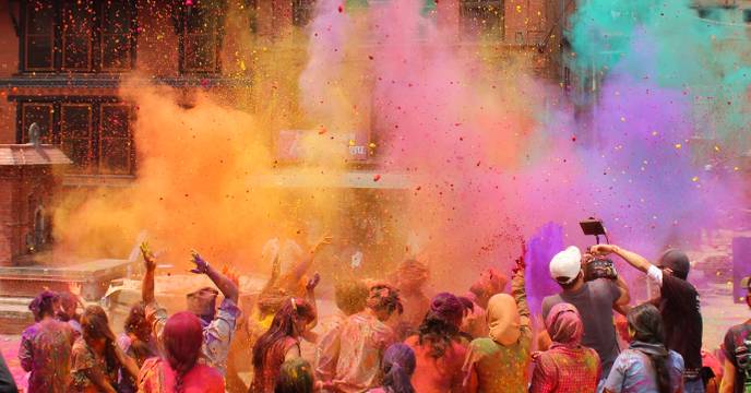 A group of people throwing colourful powder into the air at the Holi Festival in India