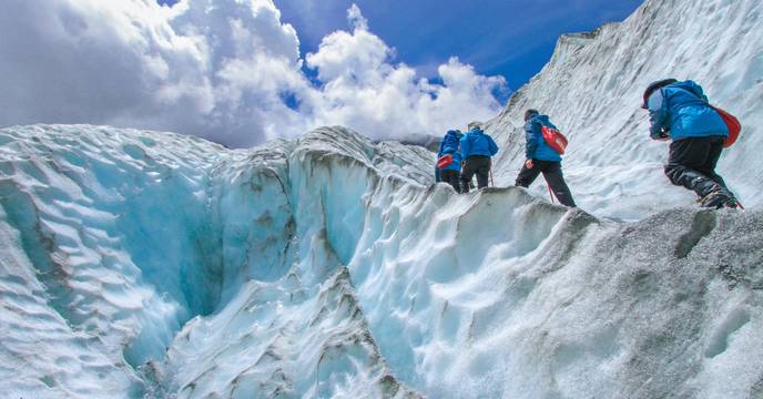 A group of people trekking on a snowed landscape