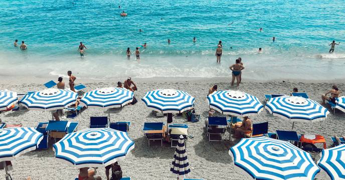 People relaxing at the beach and swimming in the blue sea