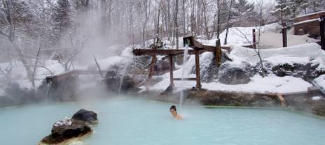 A person relaxing in a hot spring in the winter