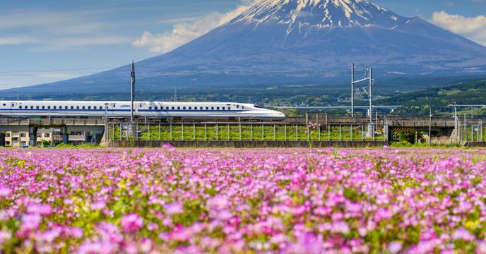 Bullet train speeding past iconic Mount Fuji
