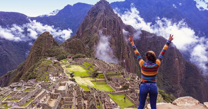 Person enjoying a panoramic view of Machu Picchu