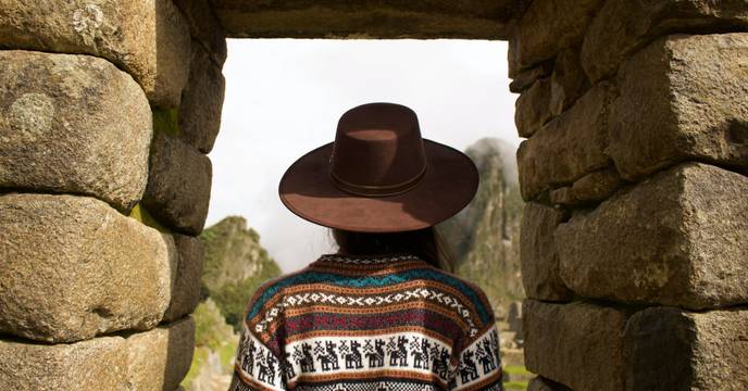 A person in a hat standing in the Intipunku (the Sun Gate)