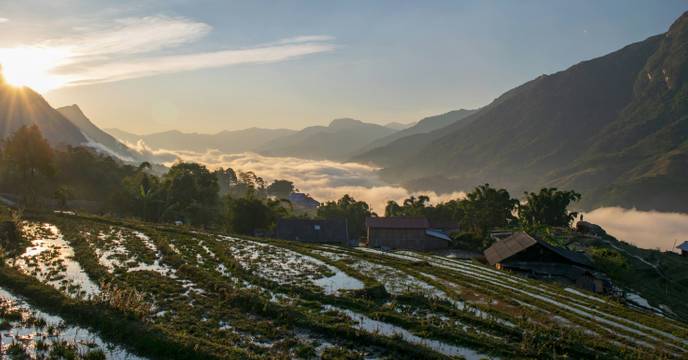 Wet terraced rice fields and the fog rising over a valley