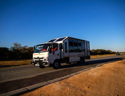 An overland truck riding over the dusty African plains