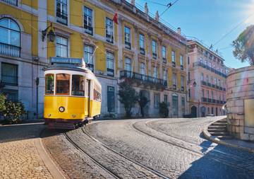 Tranvía pasando por calles coloridas en Lisboa, Portugal.