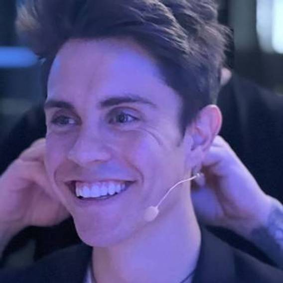 Raffaele Murgia, host of the Adventure Together Podcast, smiling with a headset microphone at a TourRadar event