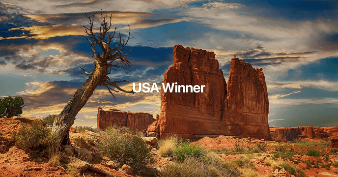 Red rock formations and vast canyon views under a dramatic sky