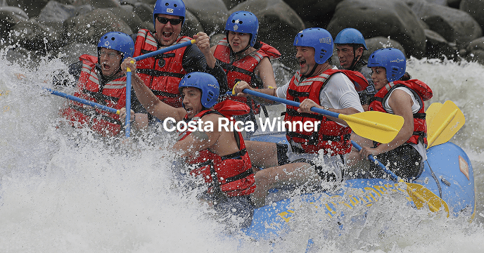 Group of people white-water rafting through a lush river canyon